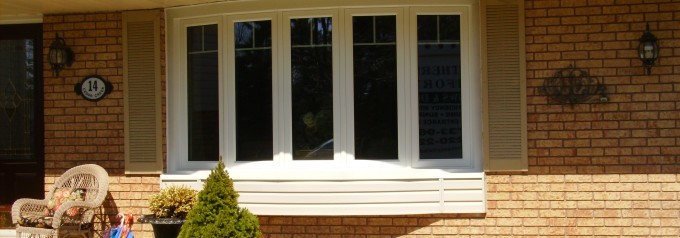 white bow windows on tan brick home